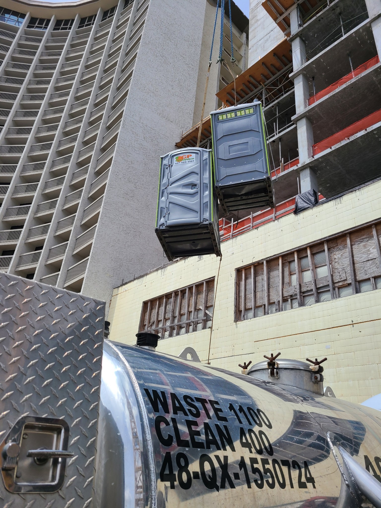 Orange County Pottys crane lift portable potty deployed at a Central Florida high rise construction site